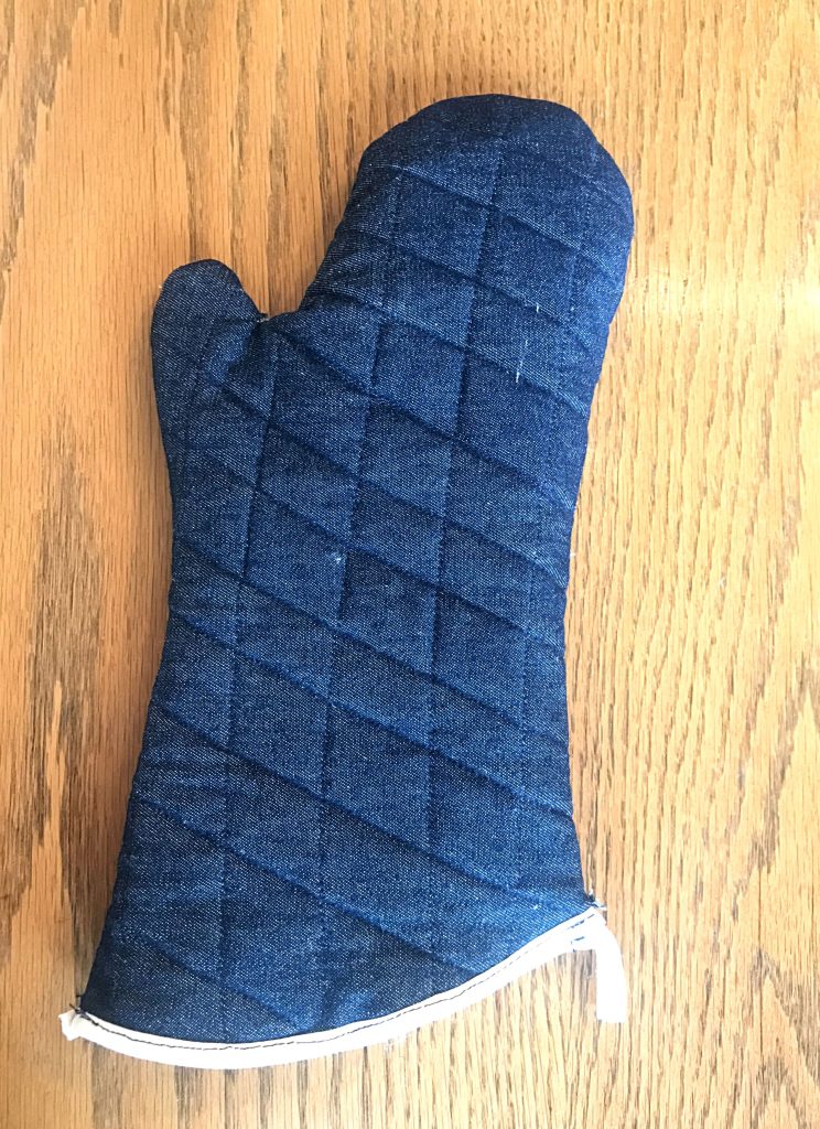 Finished hand-sewnOven Mitt on a wooden background