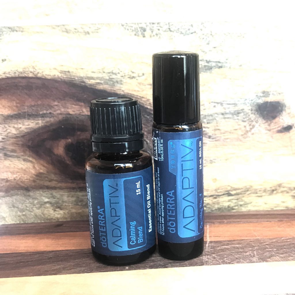 ADAPTIV 15ml and roll on calming blend Essential Oils on a wooden board