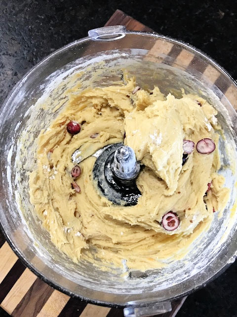 Close up view of all ingredients, including Cranberries, mixed in a food processor for scones.