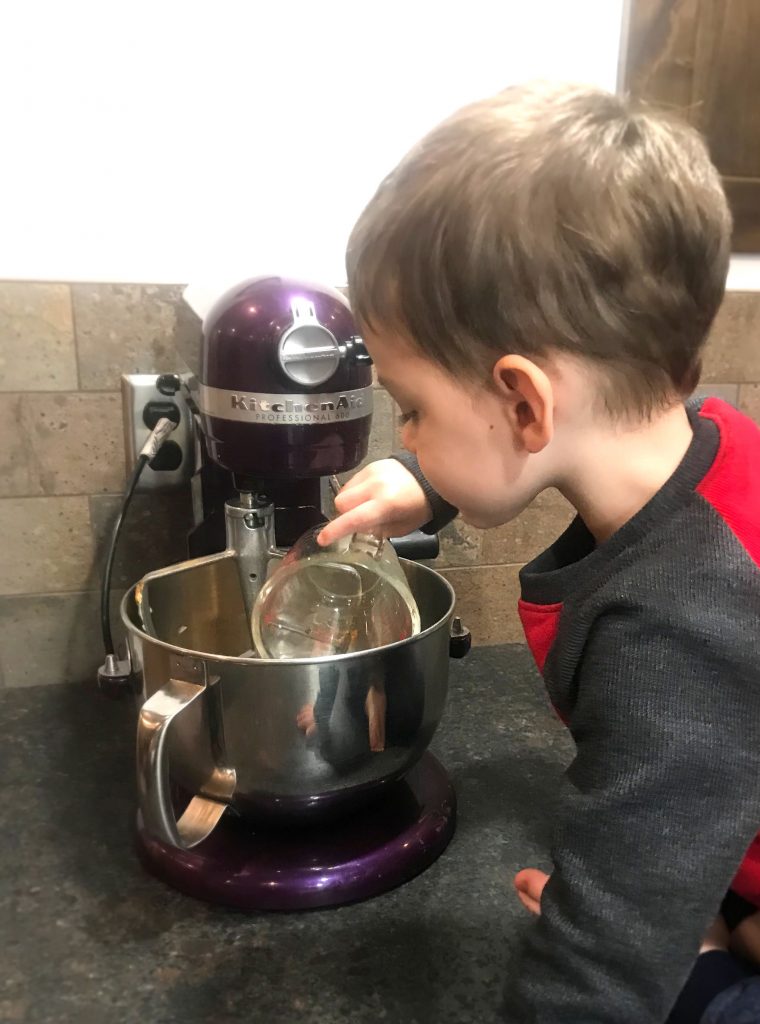 Child dumping sugar into Kitchen Aid mixer for The Best Crowd Pleaser Cookies