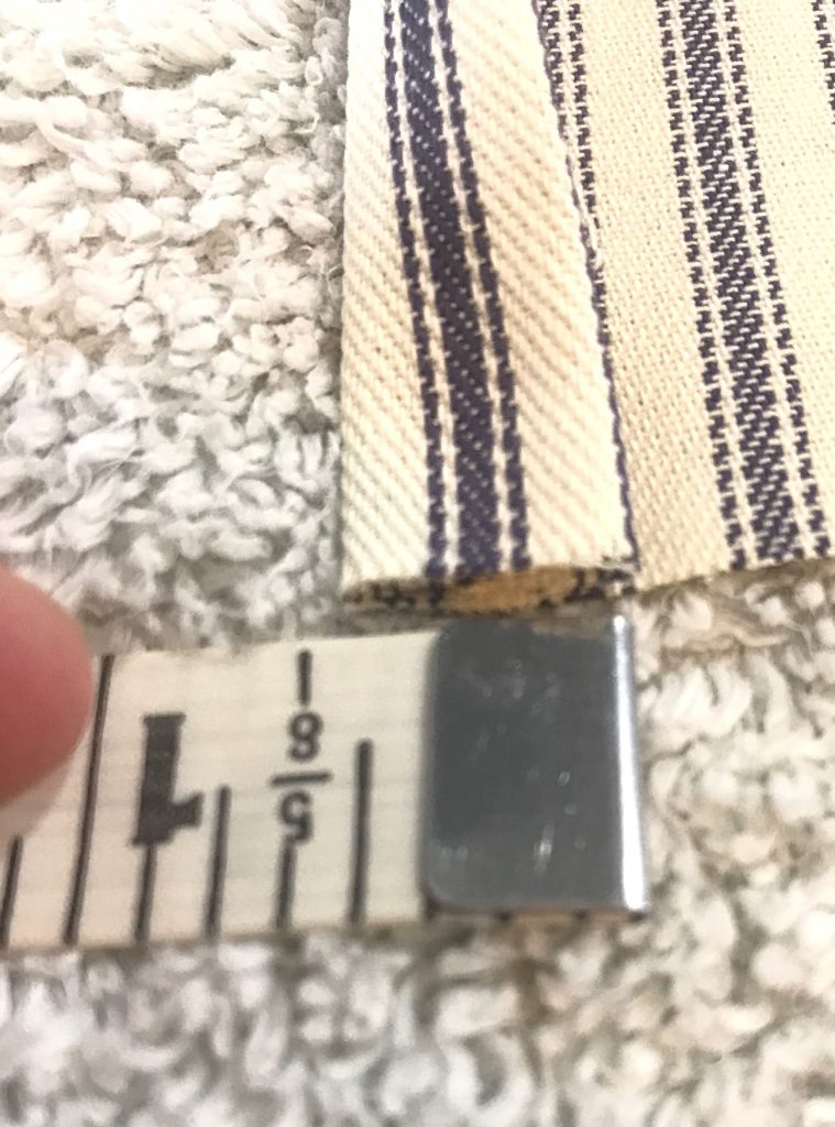 Ticking stripe fabric folded by one half of an inch on a towel