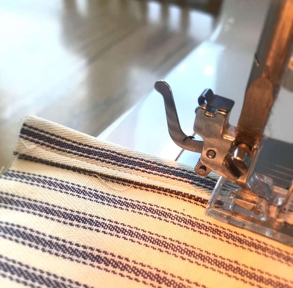 In process shot of top stitching on ticking stripe material with a sewing machine