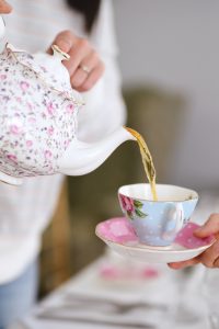 Woman pouring tea into a tea cup