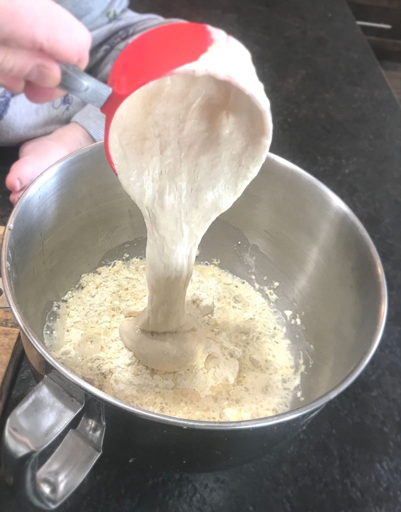 Sourdough starter being added to a silver bowl