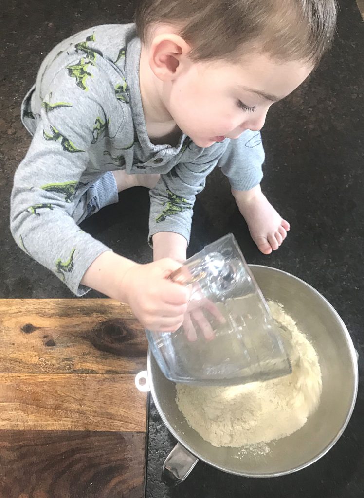 Boy dumping filtered water into a bowl for homemade tortillas