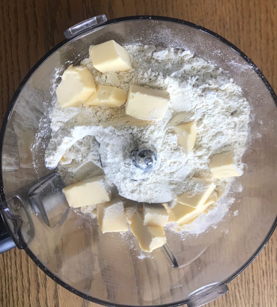 Einkorn flour and grass-fed butter cut into chunks in a food processor
