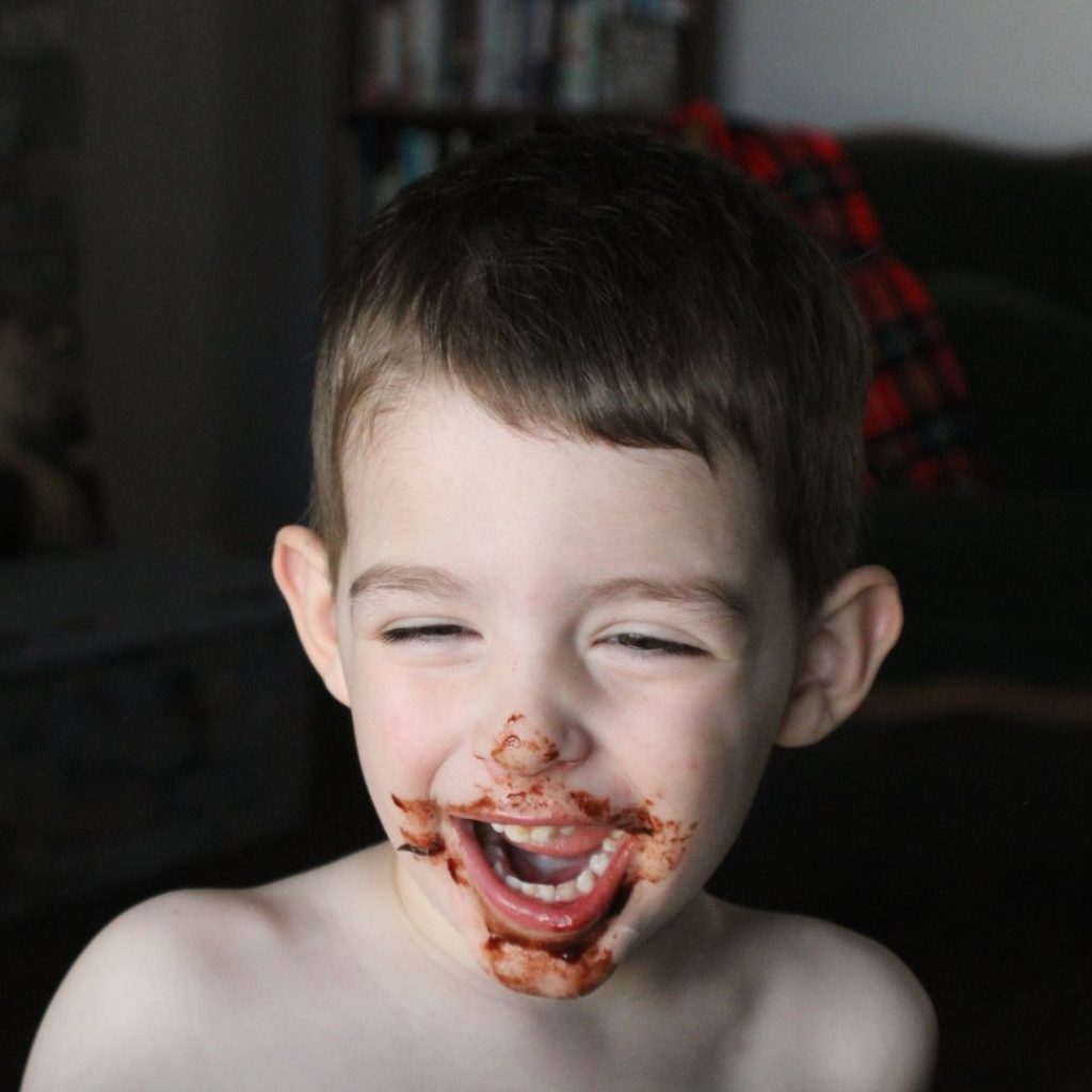 boy smiling with chocolate on his face 