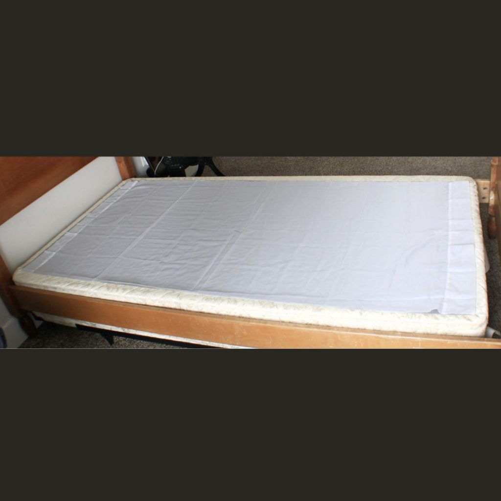 Base material cut and placed on a box spring for a bedskirt