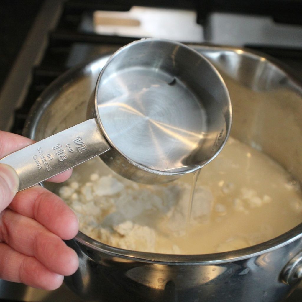 Water being poured into a pot with flour and other ingredients